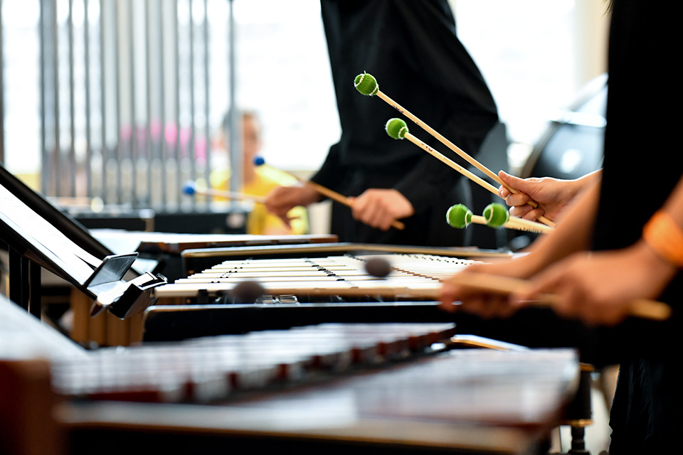 People's hands playing the marimbas with beaters